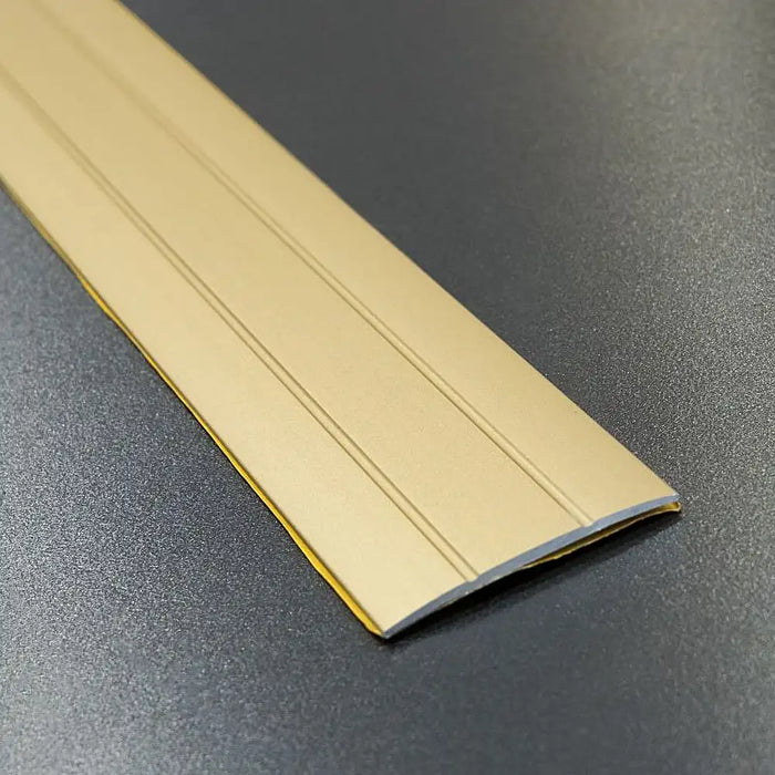 Gold coverstrip profile with a warm metallic accent.