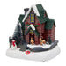 Red log house scene with a green roof, reindeer, a snowman and snowy trees on a white base