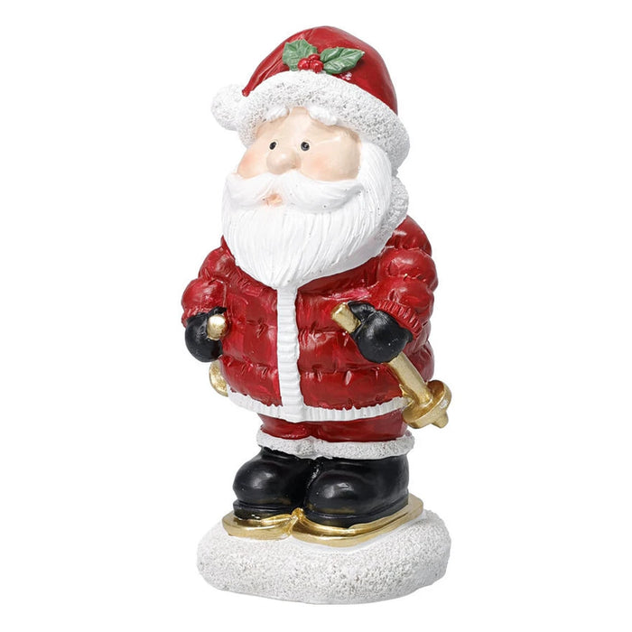 Santa figurine in a padded red jacket with skis and a pole on a snowy base