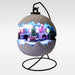 Lit snowball-shaped village scene on a black stand with a Christmas tree and train