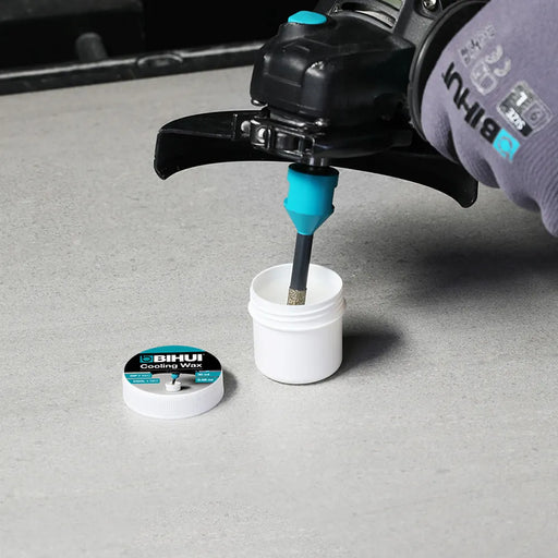 Product shot showing Bihui Cooling Wax 50ml alongside drill bits and tile surface in a workspace setting.