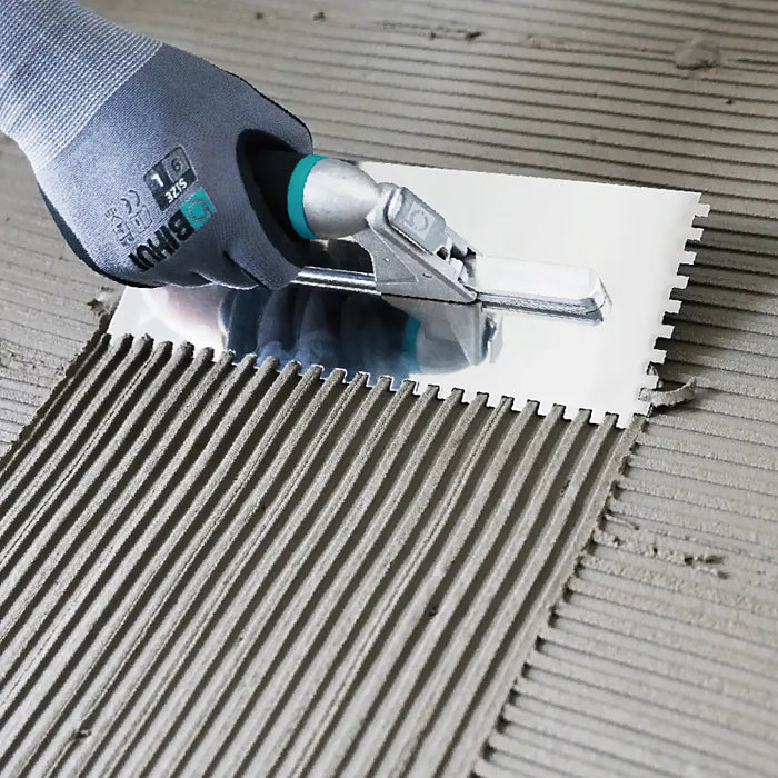 Bihui Jumbo 8 Piece Trowel Set displayed on a workbench with adhesive and tiles, showing full range of trowels and notches.