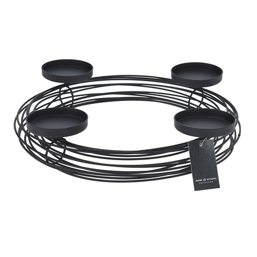 Close-up of black candle holder wreath showing circular metal frame and candle placements.