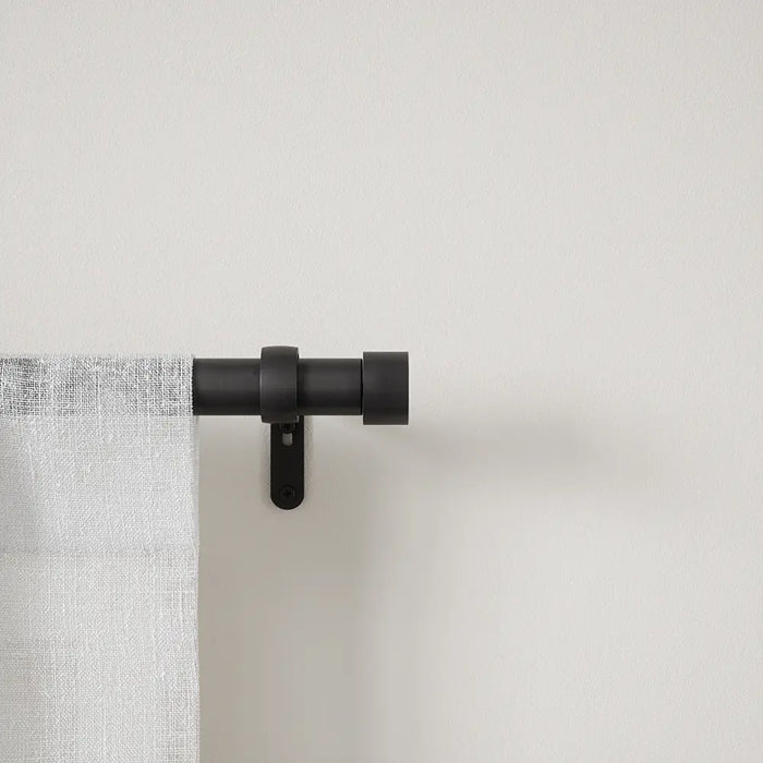 Cappa matt black extendable metal curtain pole with finials and wall brackets laid out for installation