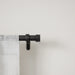 Cappa matt black extendable metal curtain pole with finials and wall brackets laid out for installation