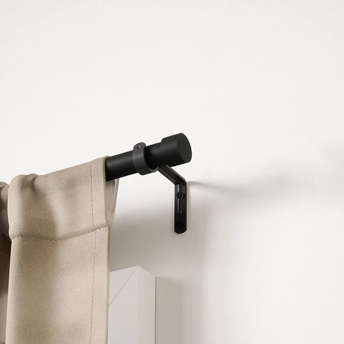 Cappa matt black extendable metal curtain pole with finials and wall brackets laid out for installation
