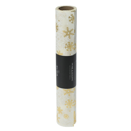 Close-up of cream fabric with gold snowflake embroidery.