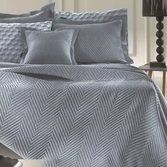 Denim Margot bedspread styled on a bed, showing deep denim blue quilted finish in a stylish room setting.