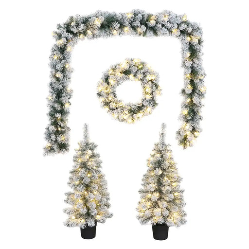 Close-up of snowy garland showing pinecones, faux greenery, and glowing LED lights.