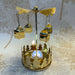 Close-up of gold house carousel tealight holder with detailed house silhouettes and spinning top.