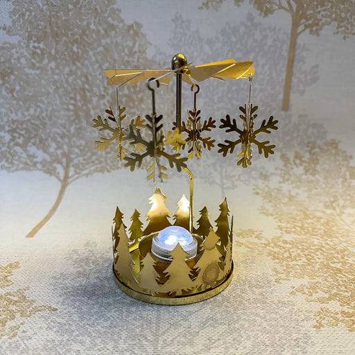 Close-up of spinning gold snowflake carousel tealight holder showing intricate snowflake cutouts.