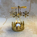 Close-up of spinning gold snowflake carousel tealight holder showing intricate snowflake cutouts.