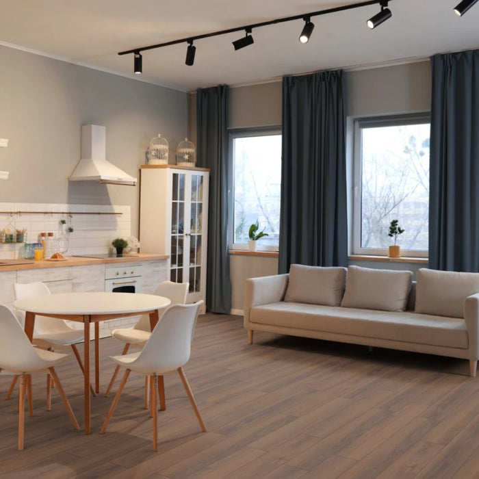 Room setting featuring Grizzly Montreux Oak laminate flooring in a classic plank pattern with natural lighting enhancing the warm brown tones.