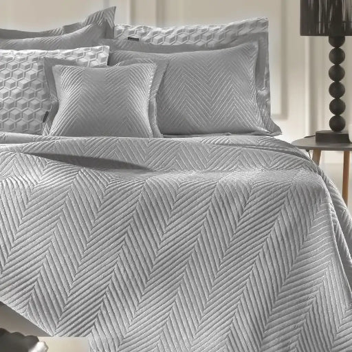 Light Grey Margot bedspread styled on a bed in a contemporary bedroom, showing quilted fabric in a neutral shade.