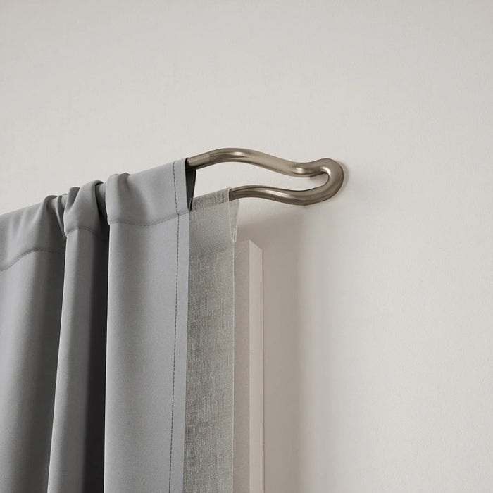 Midnight matt nickel double wrap-around curtain pole fitted with two layers of curtains for reduced light leakage