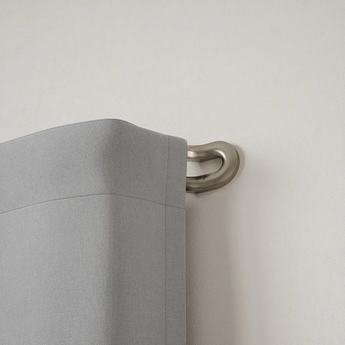Midnight matt nickel double wrap-around curtain pole fitted with two layers of curtains for reduced light leakage
