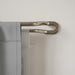 Midnight matt nickel double wrap-around curtain pole fitted with two layers of curtains for reduced light leakage