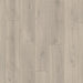 Close-up of Oak Mistral Grey laminate plank, revealing subtle wood knots and flowing grain patterns in a soft grey finish with a natural texture.