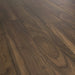 Close-up of Noce Rubio Solid 12mm laminate flooring showing warm walnut tones and realistic woodgrain texture.