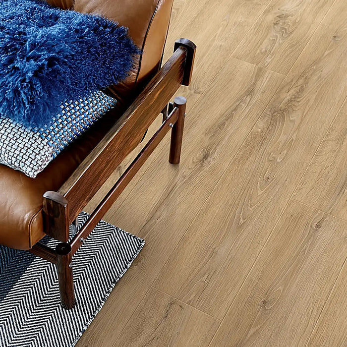 Room with Pergo Arendal Moorland laminate flooring in a spacious, sunlit interior featuring warm brown planks and natural wood variation for a rustic look.