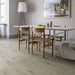 Minimalist dining room with Pergo Glomma Grey Eifel LVT flooring and bright natural light.
