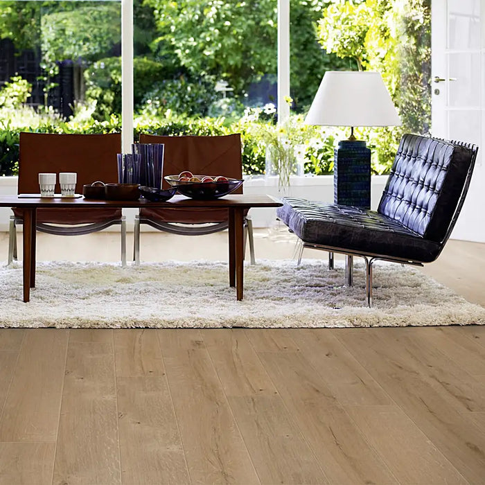 Modern living area with Pergo Namsen Greige Forest LVT in soft grey-beige oak tones.