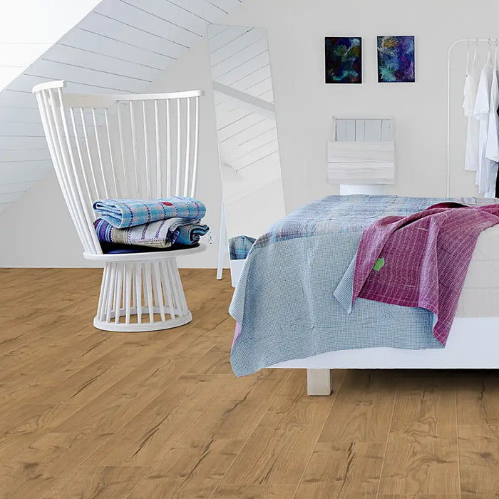 Bright bedroom with Pergo Namsen Light Cabin LVT in pale oak tones.