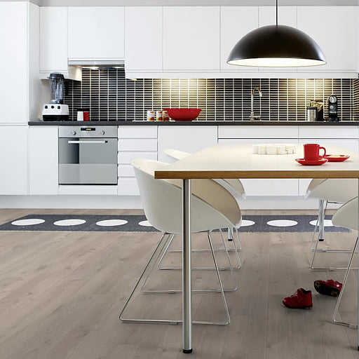 Light-filled dining space with Pergo Namsen Light Lakeland LVT in soft beige-toned oak.