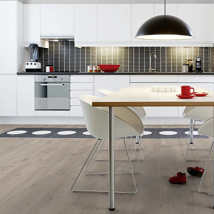 Light-filled dining space with Pergo Namsen Light Lakeland LVT in soft beige-toned oak.