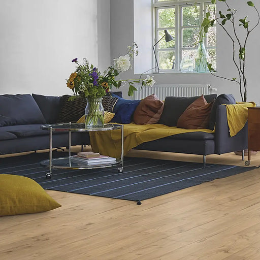 Cosy living room with Pergo Namsen Smoked Cabin LVT in warm smoked oak tones.