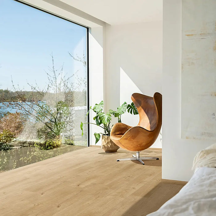 A bright, contemporary room featuring Pergo Namsen Soft Ardeche LVT, with natural oak-inspired planks that have a soft, muted beige tone.