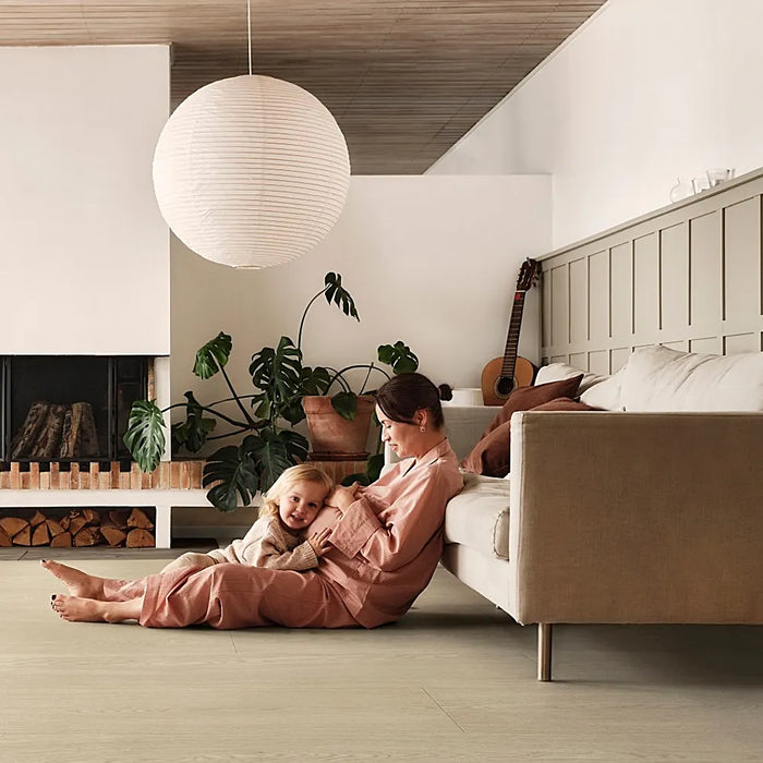 Modern living space featuring Pergo Odense Clay laminate flooring in rich taupe, paired with soft furnishings and natural accents.