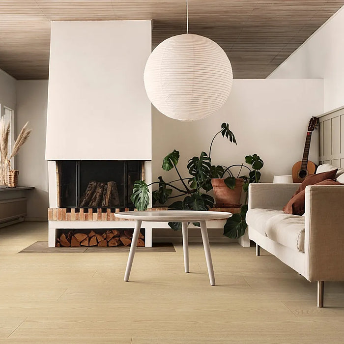 Living room with Pergo Odense Malt laminate flooring in warm caramel tones, styled with natural light and cozy neutral decor.