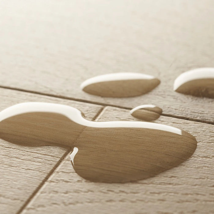 Pergo Visby Coastal laminate flooring styled in a bright, contemporary living space with natural light and soft beige tones creating a coastal, airy feel.