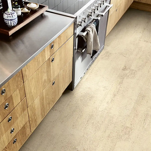 A modern kitchen with Pergo Viskan Dry Sandstone flooring, showing natural beige stone tones.
