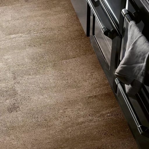 Kitchen with Pergo Viskan Wet Sandstone flooring, showing warm beige stone-like tones.