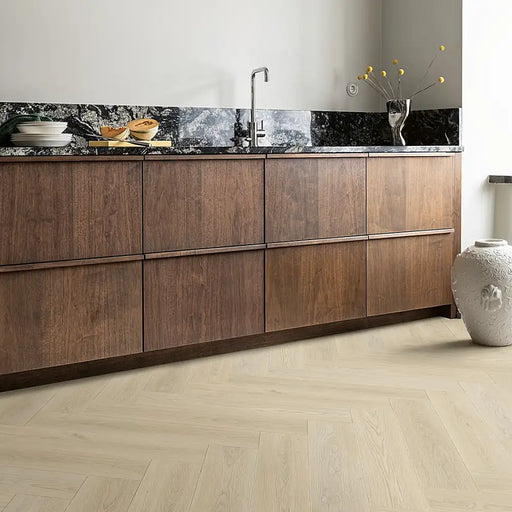 Light Norwegian herringbone LVT flooring in a bright kitchen room with natural wood tones.