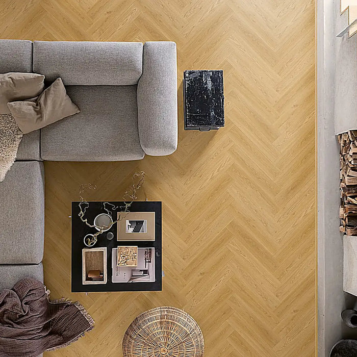 Warm Norwegian herringbone LVT flooring in a cosy living room with honey-toned wood effect.