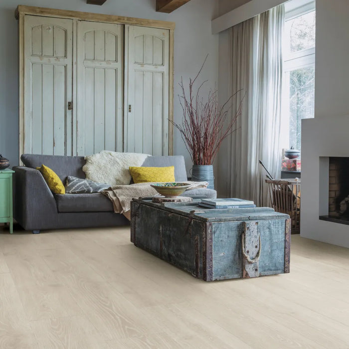Room setting featuring Quick-Step Majestic Woodland Oak Light Grey flooring, with wide planks and a clean, modern grey oak finish.