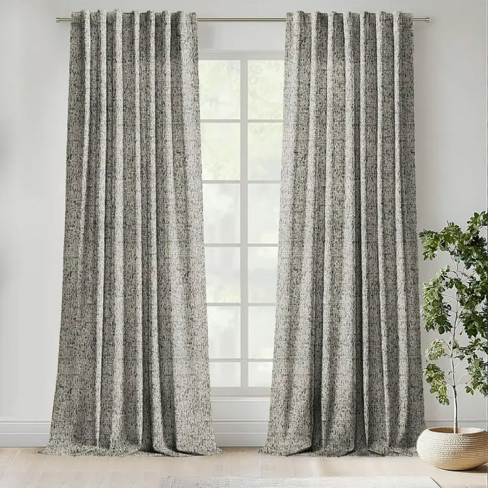 Scatter Box Yara Natural and Black bouclé eyelet curtains fully lined and hanging at a large window in a modern living room