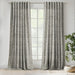 Scatter Box Yara Natural and Black bouclé eyelet curtains fully lined and hanging at a large window in a modern living room