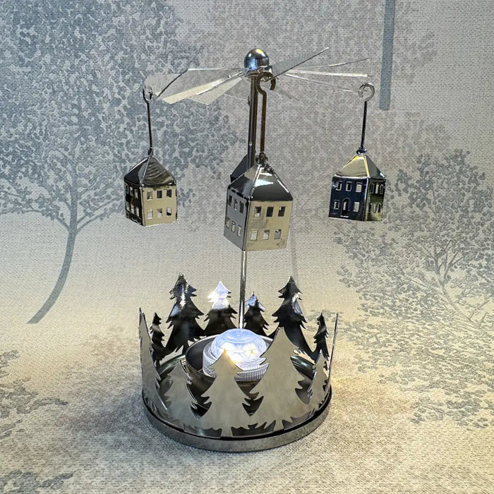 Close-up of silver house carousel tealight holder showing spinning house shapes and metallic detail.