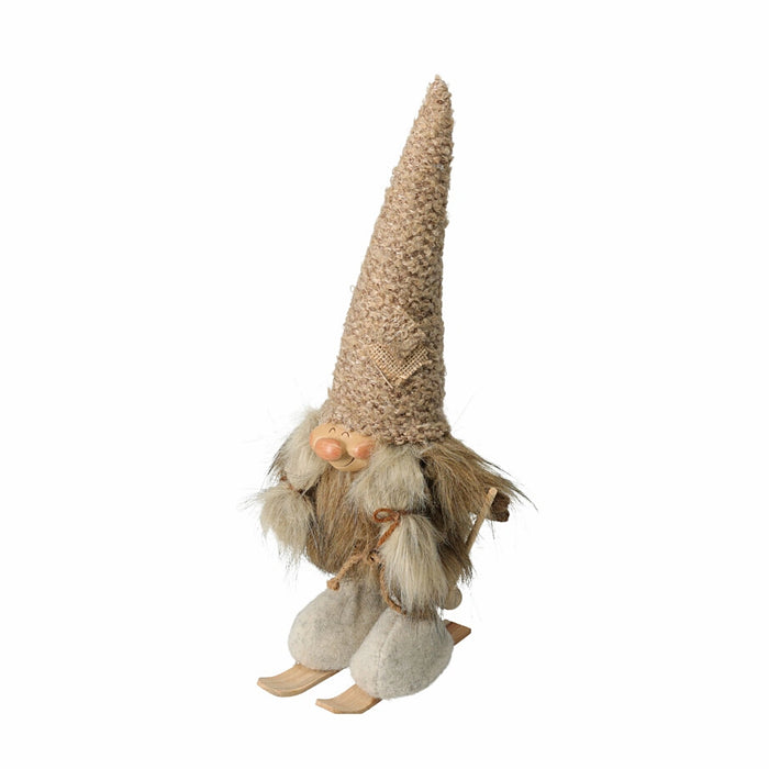 Close-up of skiing gnome woman figurine wearing winter clothes and holding skis.