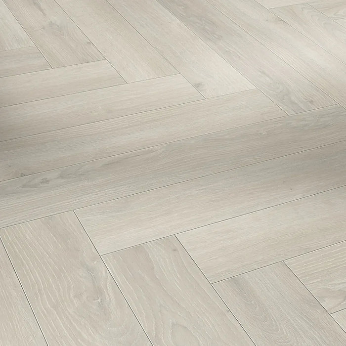 Close-up of Skyline White Herringbone laminate plank highlighting its natural matt surface, light oak texture, and realistic woodgrain detail.