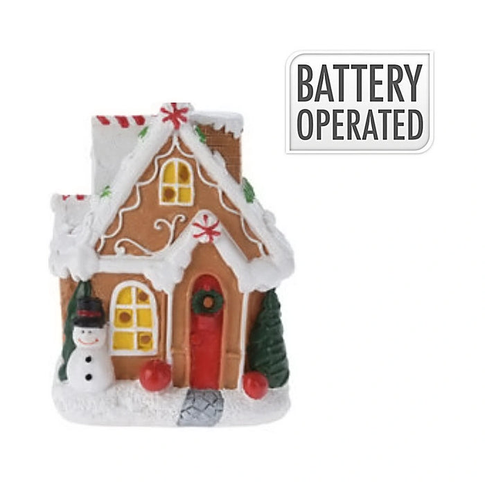 Close-up of Snowman Cookie House showing colourful icing details and glowing LED lights.