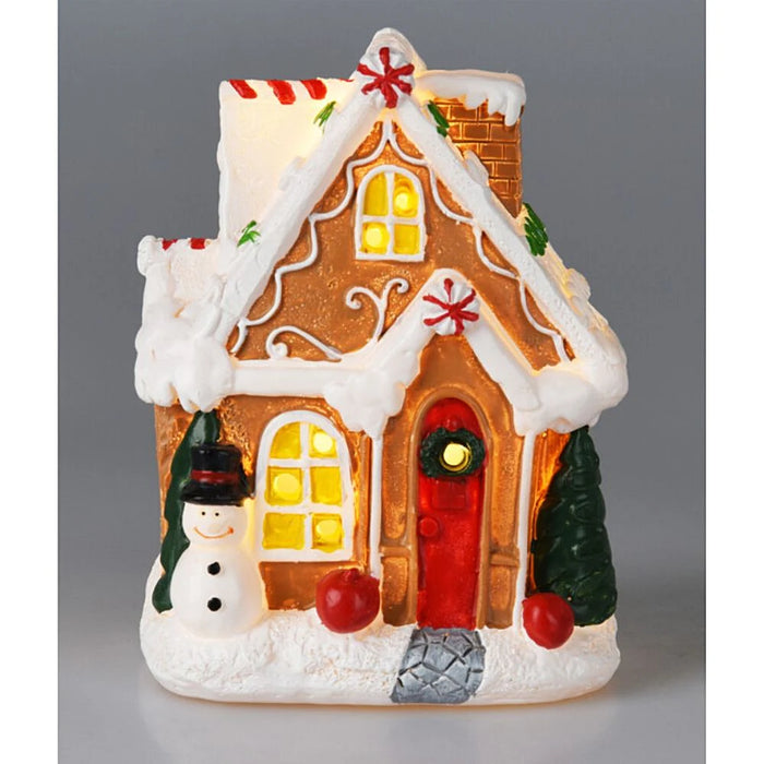 Close-up of Snowman Cookie House showing colourful icing details and glowing LED lights.