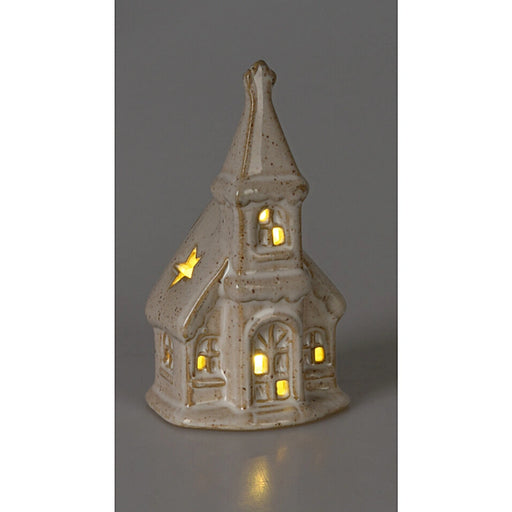 Close-up of Snowy Window Church showing illuminated windows and snow-covered details.