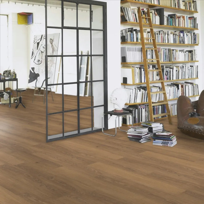 Room view featuring Parador Studioline Honey wide plank laminate flooring installed in a bright interior, highlighting its warm oak finish and realistic wood floor look.