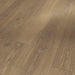 Close-up of Parador Studioline Honey laminate flooring showing its natural matt texture and warm honey tones with subtle wood grain detailing.