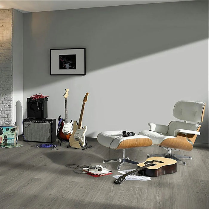 Studioline Light Grey laminate flooring styled in a minimalist living space, featuring cool grey oak tones and extra-long planks with realistic wood texture and bevelled edges.